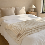 Cozella throw folded across the foot of a bed