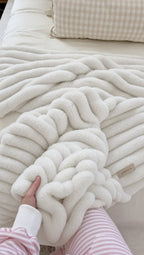 Hands pressed into the deep ribbed pile of the Cozella throw in White